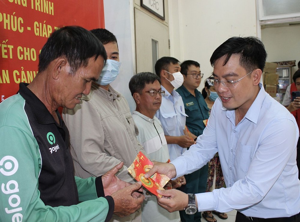 华文《西贡解放日报》编委文忠孝向贫困者赠送礼物。