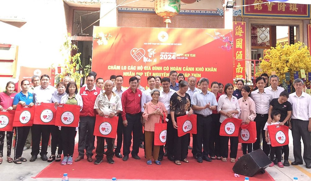 市委民运处、市红十字会领导和各会馆、企业代表与贫困者合影。