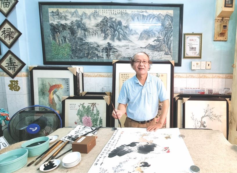 李炳全画家正在画水墨画。