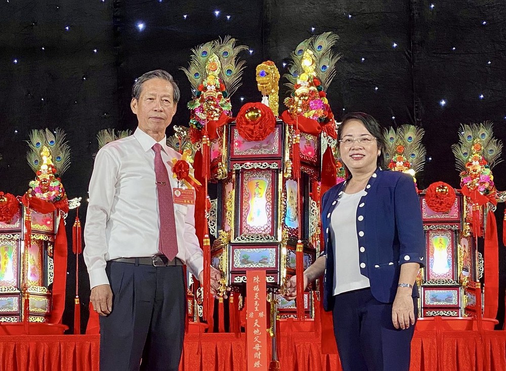 市越南祖国阵线委员会主席陈金燕向义安会馆常值副理事长陈振炎移交“天地父母财灯”。