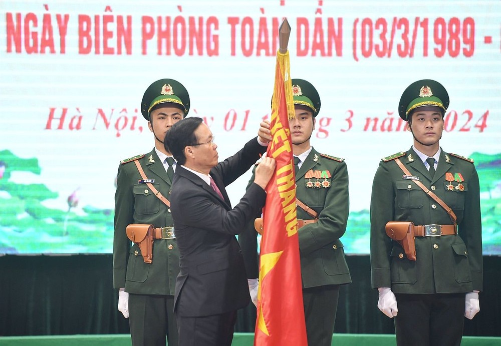 国家主席武文赏向边防部队的决战决胜旗帜别上二等战功勋章。（图：越通社）