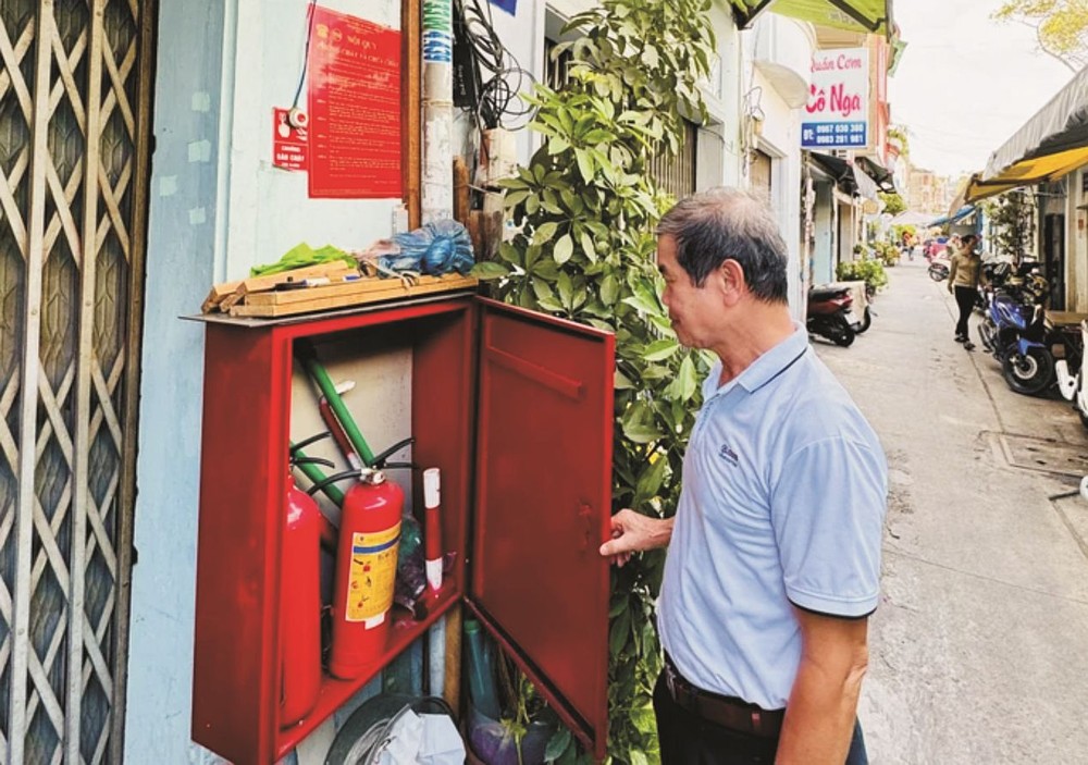  第一郡范伍老坊第五街区区长丁春誉检查联家组的消防器材柜。