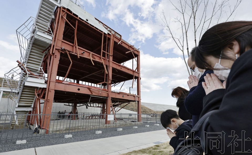 东日本大地震迎来13週年，人们在地震发生时刻朝着宫城县南三陆町的防灾对策大楼遗迹默哀。摄于3月11日下午2点46分。（图：共同社）