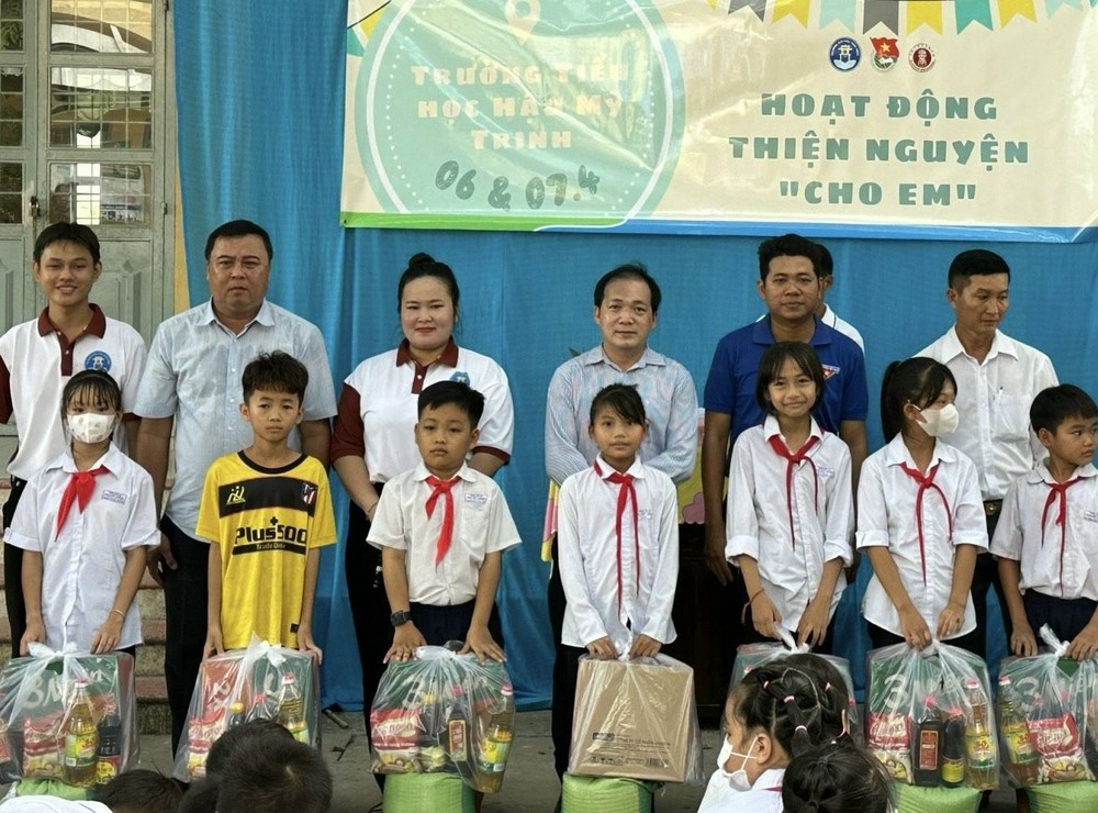 文献大学外语系副主任赖开荣与书法俱乐部成员向贫困生派发礼物。