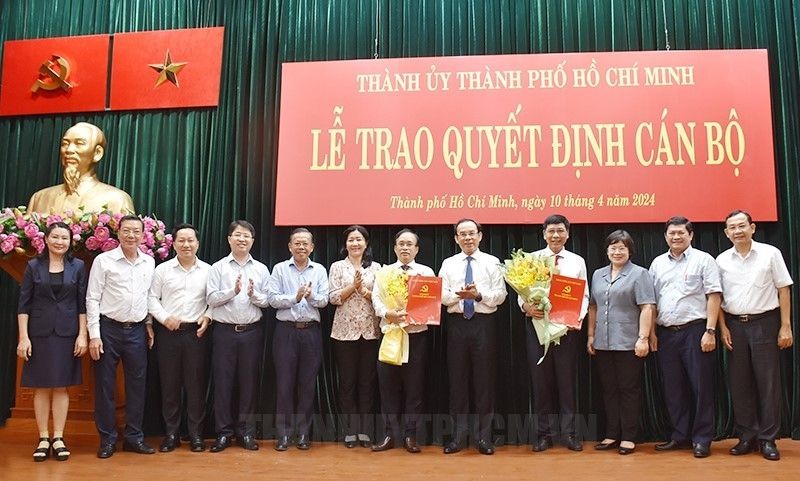 市委书记阮文年（右五）同与会代表向两位接受新任务的同志祝贺并合影留念。（图：市党部新闻网）