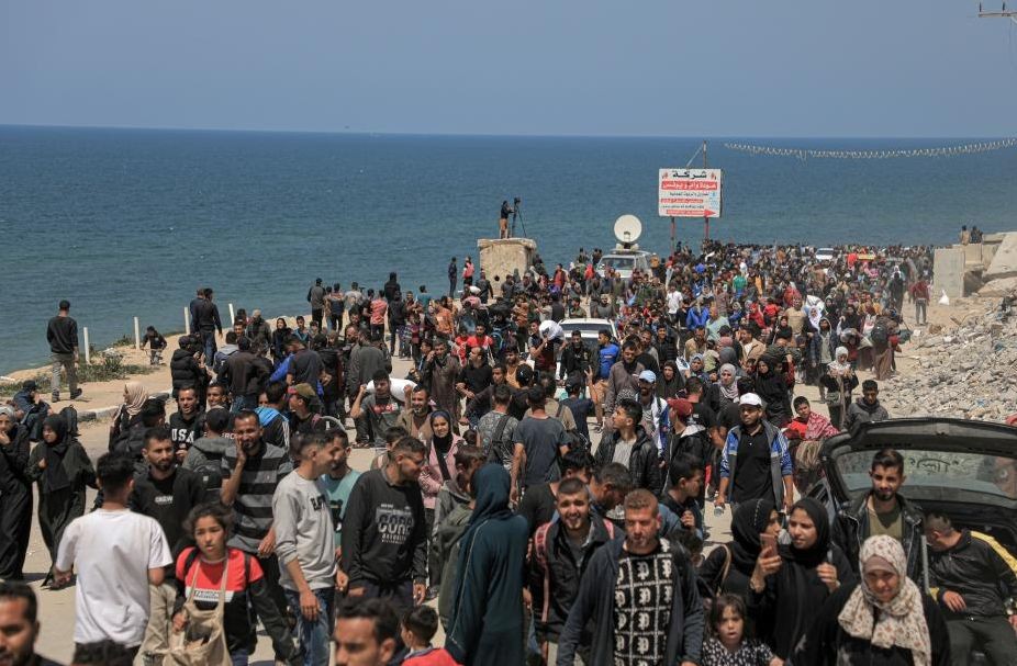 这是4月14日在加沙地带中部拍摄的向北返家的人群。（图：新华社）