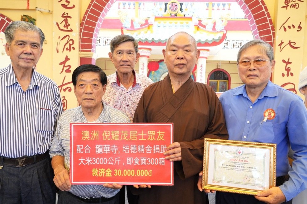 第八郡红十字辅助会会长、龙华寺住持释慧功和尚(右二)与培德精舍护法理事会常值副会长赖远东(右一)、越侨倪耀茂(右三)与代表在派发济贫礼物前合摄。