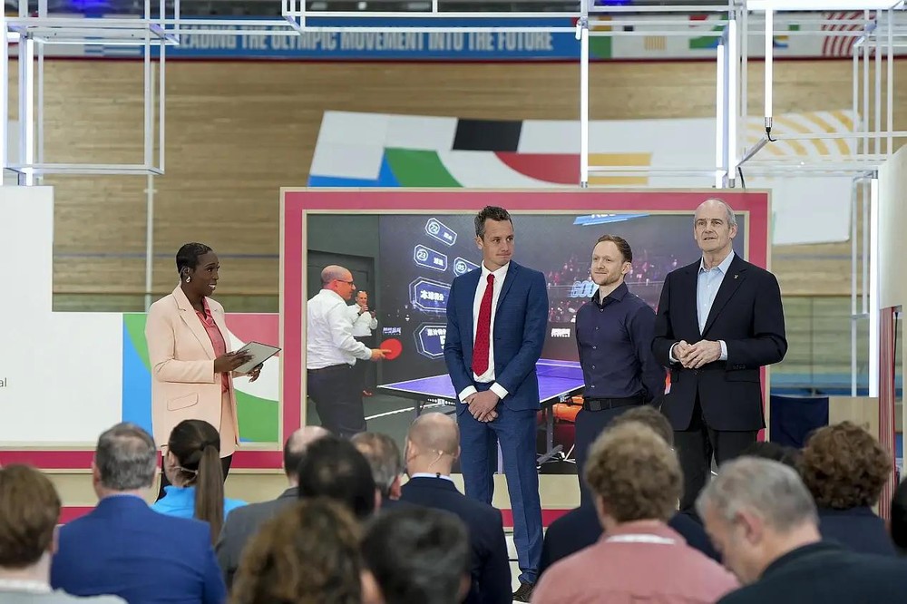 4月19日，在《奥林匹克AI议程》发布会上，嘉宾和主持人一起探讨人工智能对运动员表现的影响。（图：新华社）