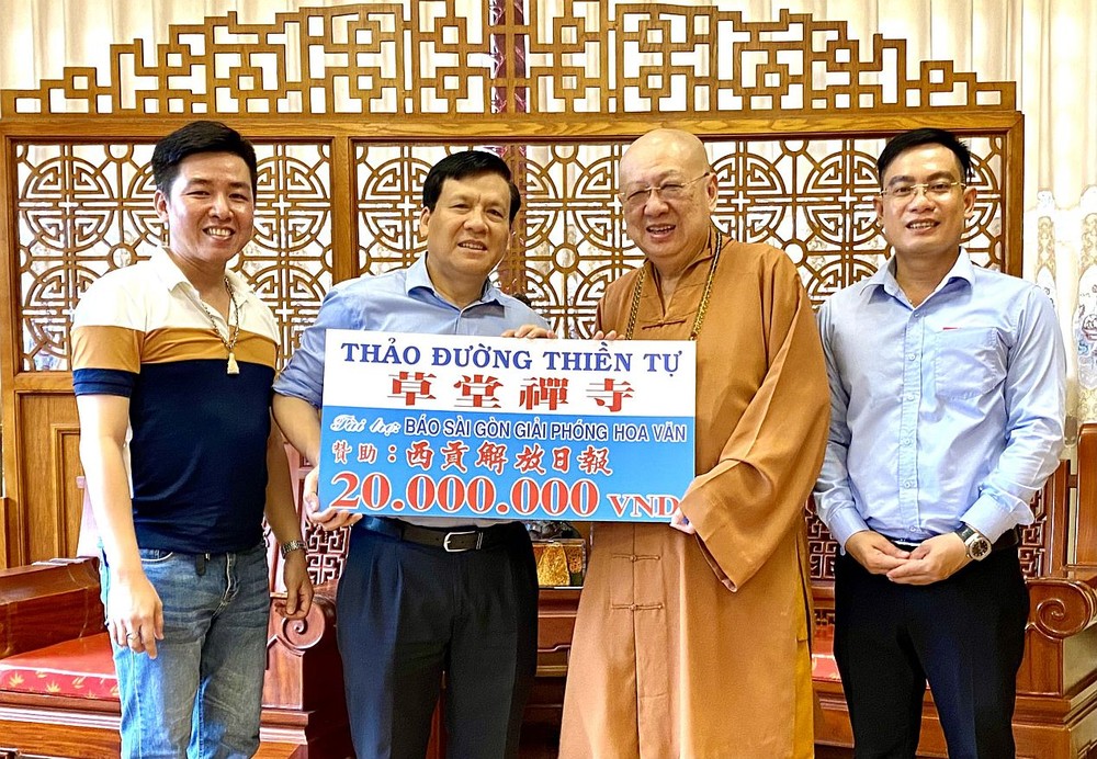 释了明法师向本报主编阮玉英转交“赠报计划”赞助2000万元。