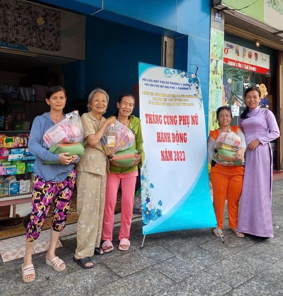 谢大娘（左二）赠送礼物给贫困户。
