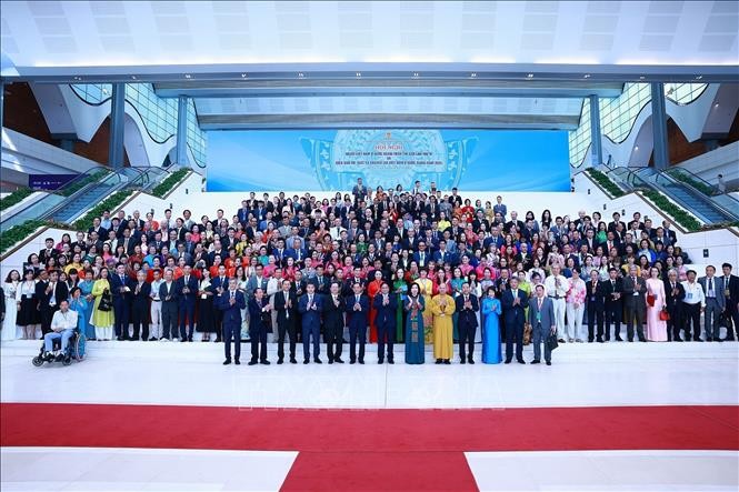 政府总理范明政和与会代表及海外越南人社群大合照。（图：越通社）