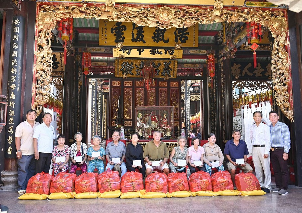 义安会馆理事长陈振炎与诸位理事会成员向贫困乡亲派发盂兰赈济品。