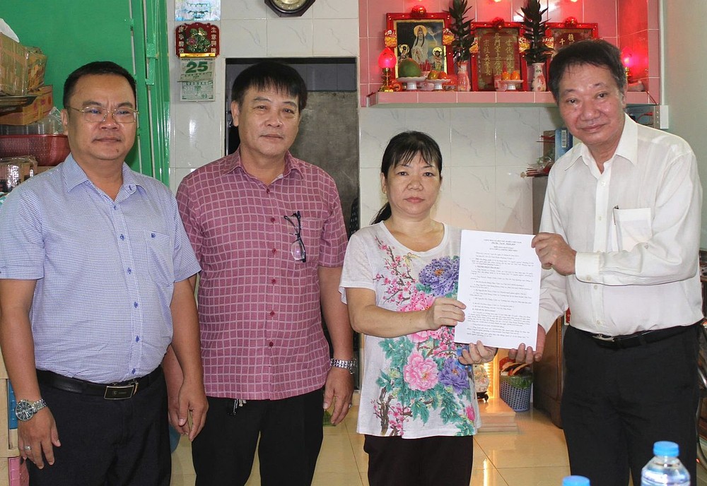 郡、坊领导与庆云南院住持周华邦(右一）向蔡美凤一户移交修缮漏水住房工程。