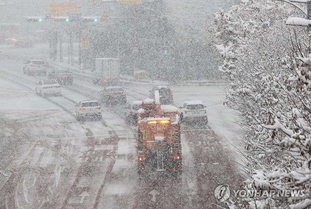 除雪车展开除雪工作。（图：韩联社）