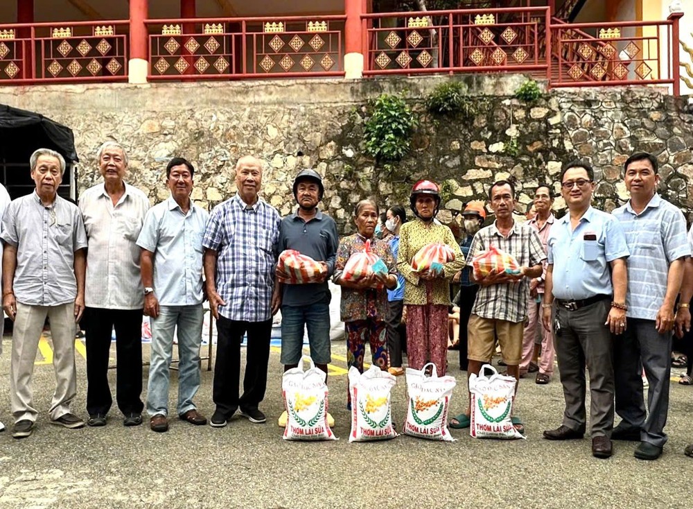 理事长邹国荣（右二）与各理监事、顾问发放礼物予穷人。