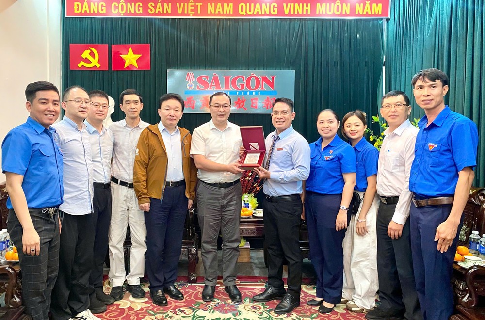 上海市共青团代表向本报赠送纪念品。