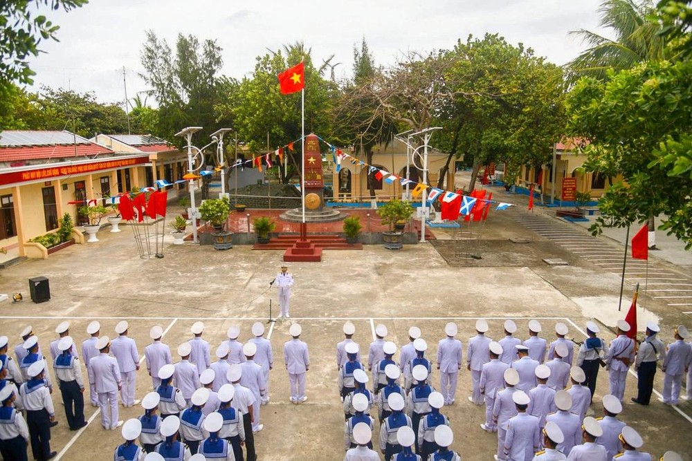在迎风飘扬的祖国神圣黄星红旗下，在主权碑前，干部、战士和群众列队进行升旗仪式。（图：辉凤）