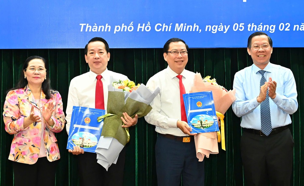 市人委会主席潘文迈、市人民议会主席阮氏丽向两位同志颁授《决定》。