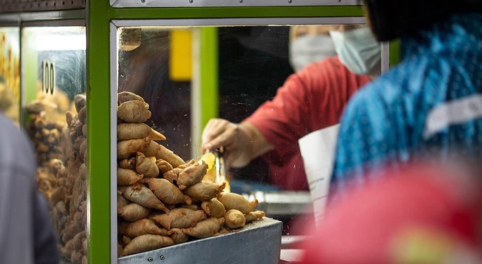 印度尼西亚雅加达的街头小贩在摊位上卖油炸食品。（图：UNICEF）