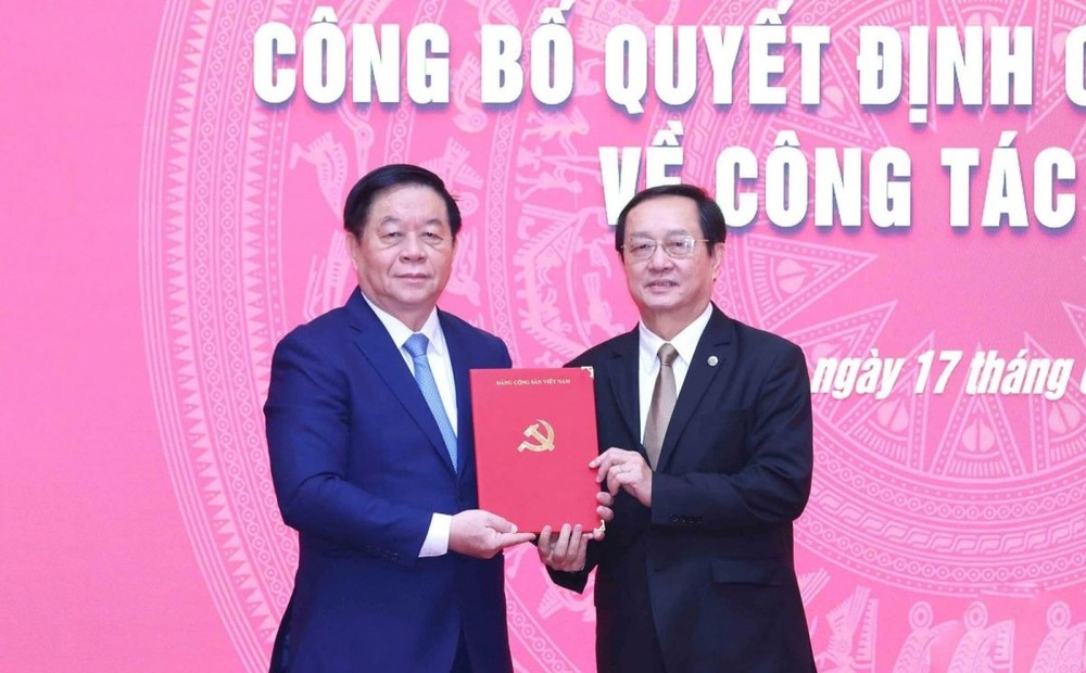 中央宣教与民运部长阮仲义（左）向黄成达同志颁授《决定》