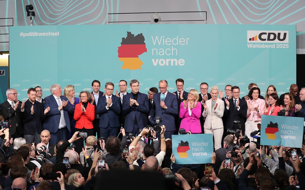 在德国柏林的基督教民主联盟总部，联盟党总理候选人默茨(中)在出口民调显示领先后接受祝贺。（图：新华社）