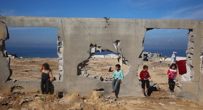 孩子们聚集在一栋被摧毁的建筑前。（图：联合国）