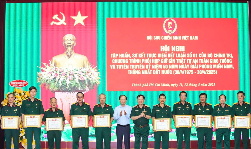 中央宣教与民运部副部长范必胜、越南退伍军人协会副主席屈越勇中将向模范退伍军人颁授奖状。（图：锦雪）