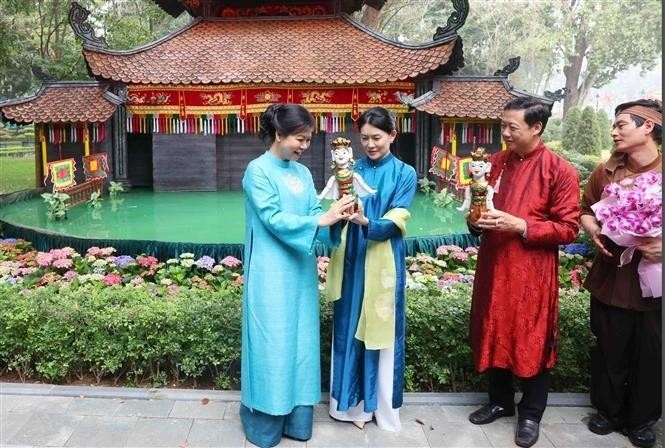 党中央总书记夫人与新加坡总理夫人共赏水上木偶戏。（图：越通社）