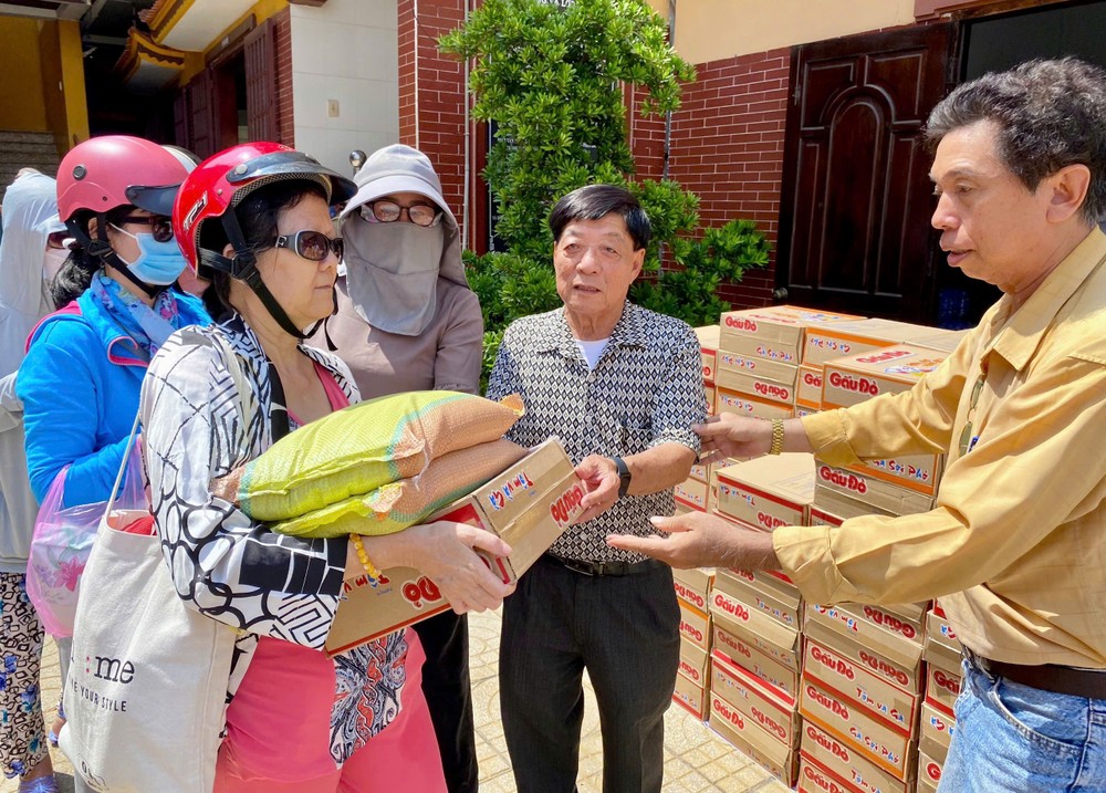 热心人士倪耀茂（右二）向视障人士发送方便面和大米。