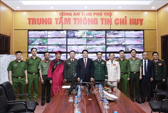 国家主席梁强（中）与富寿省公安指挥资讯中心干部合影。（图：越通社）