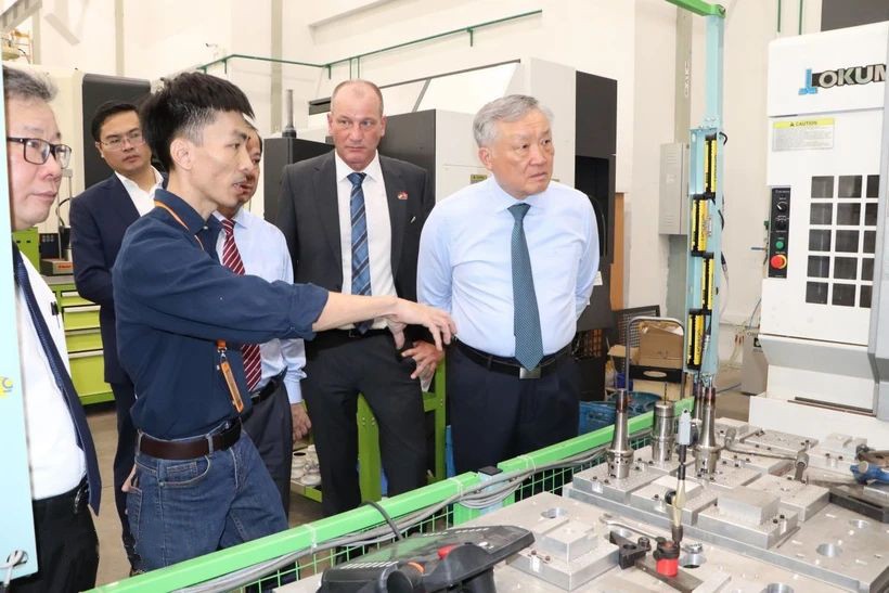 政府常务副总理阮和平（右一）参观越德大学技术系。（图：越通社）