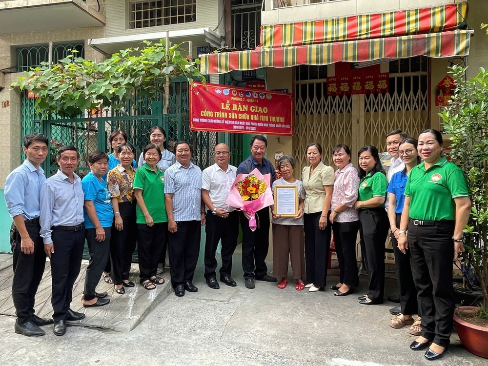 郡、坊领导和庆云南院住持周华邦向一贫困户移交修缮“温情屋”工程。