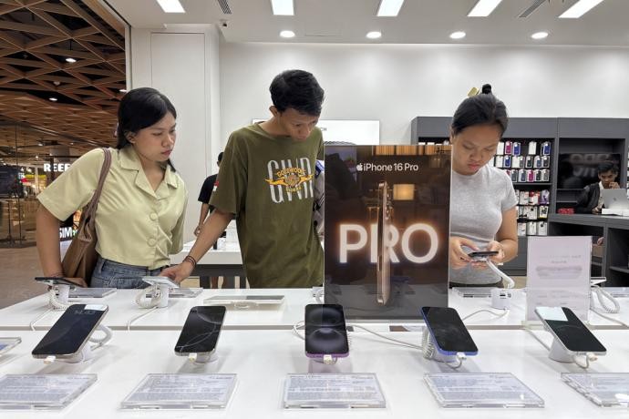 在印尼峇厘省登巴萨市一家苹果产品专卖店，消费者11日查看当天正式发售的iPhone 16系列手机。（图：欧新社）