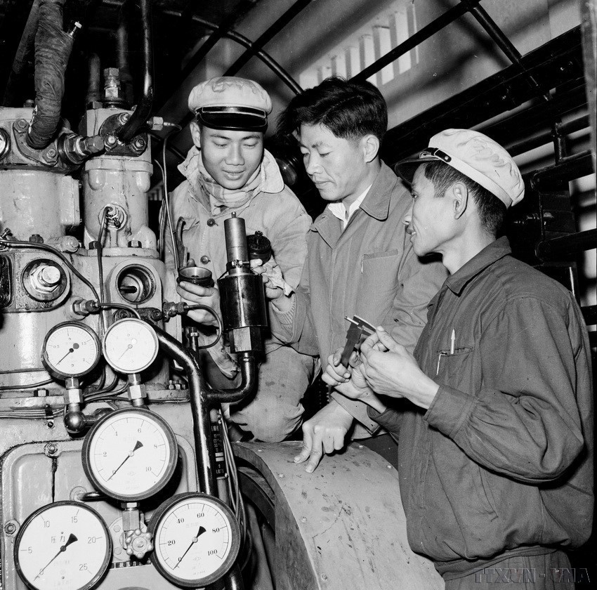中国专家（中间）在K65厂房中指导越南工人拆卸、修理自动排气阀（1960年9月）。（图：越通社）