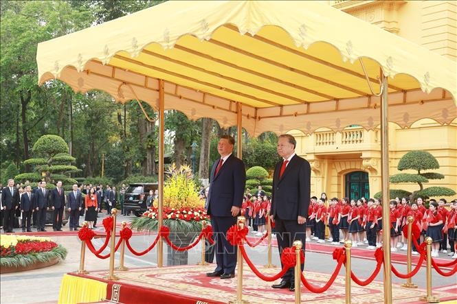 苏林总书记和习近平总书记在主席台上，聆听军乐演奏两国国歌。（图：越通社）