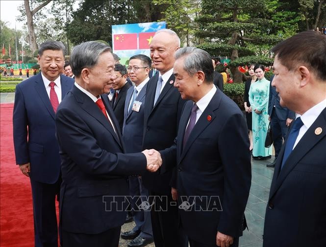 中共中央总书记、中国国家主席习近平向苏林总书记介绍中方高级代表团成员。（图：越通社）