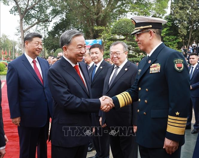 中共中央总书记、中国国家主席习近平向苏林总书记介绍中方高级代表团成员。（图：越通社）