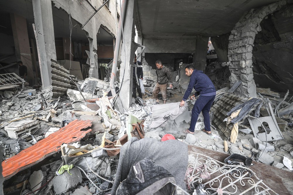 在加沙地带北部的杰巴厘耶难民营，民众查看以军袭击后的废墟。（图：新华社）