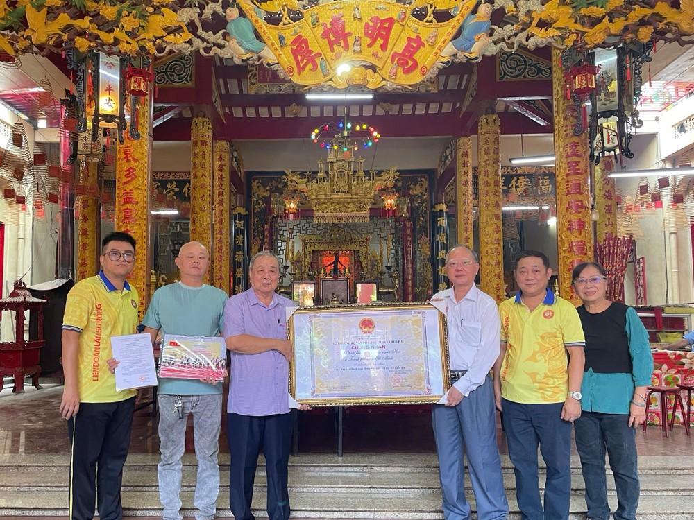 市龙狮协会主席卢耀南、副主席阮玉秀向海南会馆理事会代表赠送市华人龙狮艺术获列入国家级非物质文化遗产名录认证。