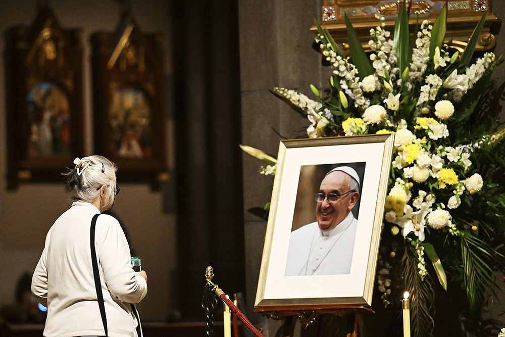 图为 4月22日，一名信徒在澳大利亚圣帕特里克大教堂内悼念教皇方济各。（图：互联网）