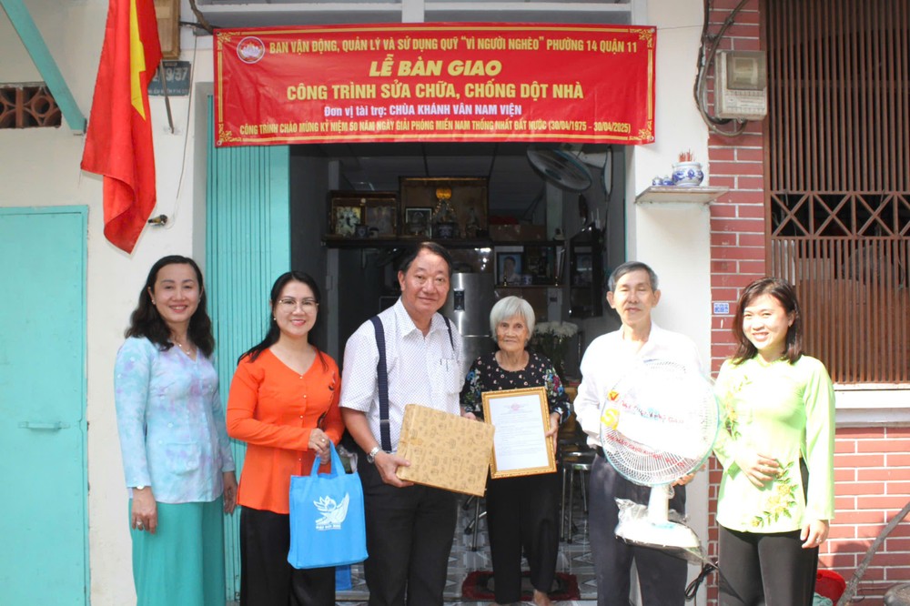 郡、坊领导与庆云南院住持周华邦向阮氏美芝一户移交修缮“温情屋”工程。