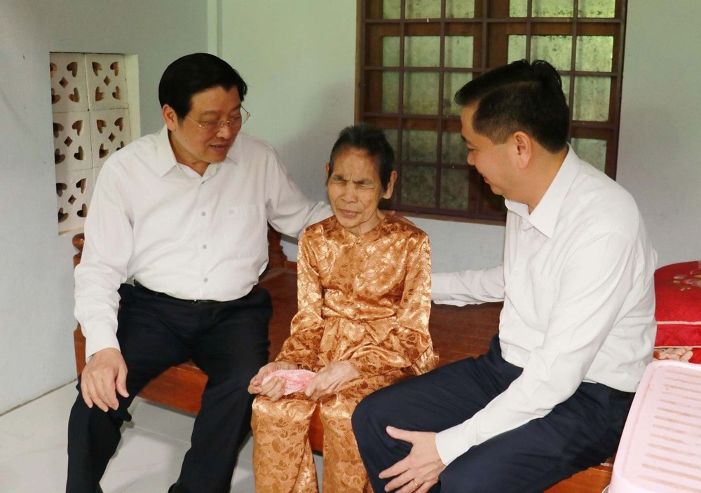 中央内政部长潘廷擢（左一）亲往广治省儒灵县丰平乡嘉门村探望越南英雄母亲阮氏撬并赠送礼物。（图：T.T）