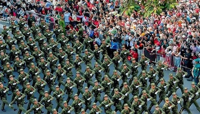 基层治安的男子力量方队在挥手欢迎的人海中。