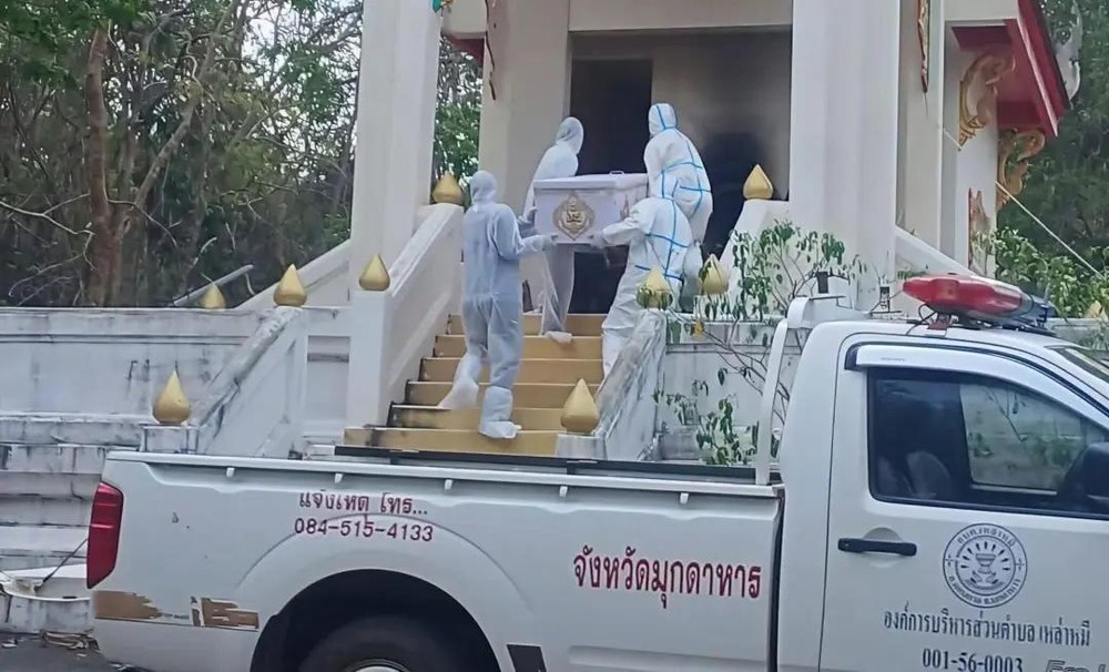 相关人员“全副武装”把棺木抬进焚化炉。（图：互联网）