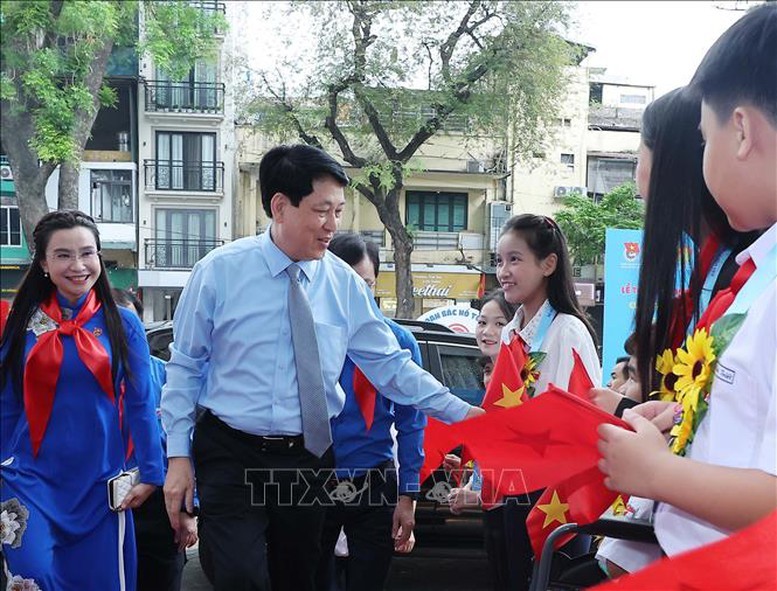 国家主席梁强微笑着向夹道欢迎的少先队员们致意。（图：越通社）