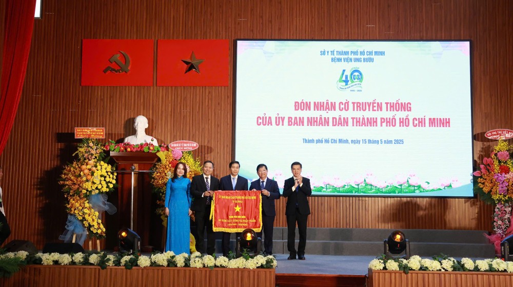 市人委会副主席阮文勇代表市领导向市肿瘤医院颁赠传统锦旗。