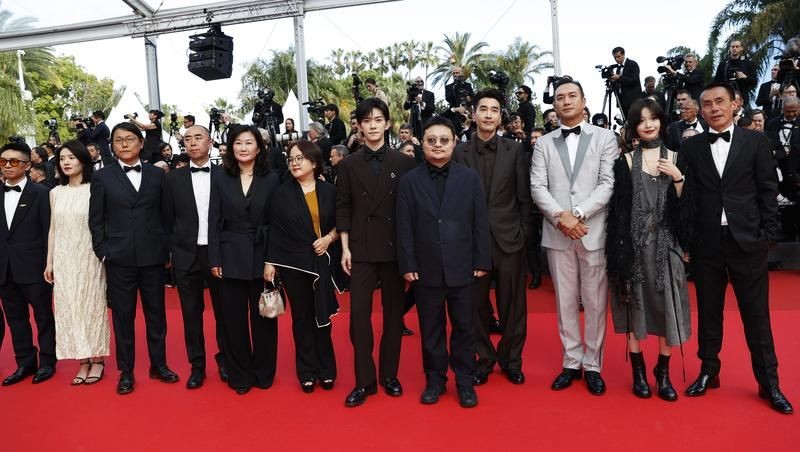 中国影片《狂野时代》导演毕赣(右五)携主创人员踏上闭幕式红毯。