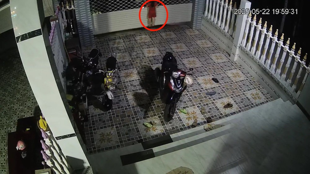 女童在卷帘门上升时攀爬（红圈示）。（图：视频截图）