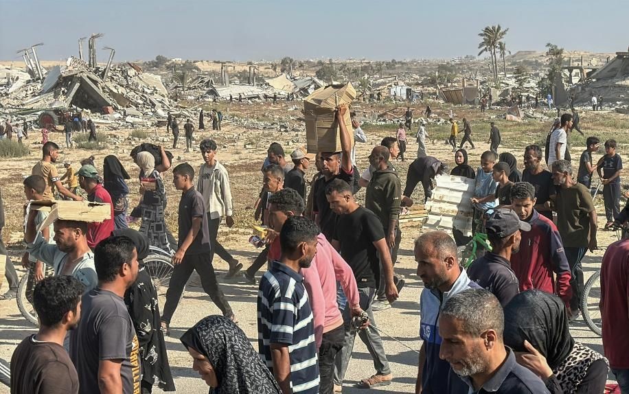 5月27日，在加沙地带南部城市拉法，民众从“加沙人道主义基金会”运营的一个物资分发中心领取救援物资。（图：新华社）