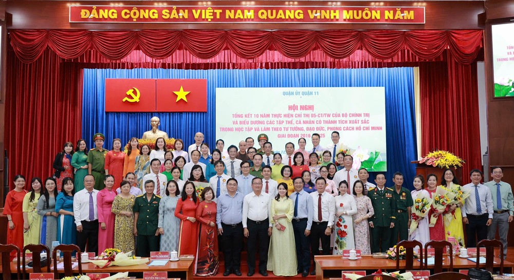 市、郡领导与积极傚法胡志明思想、道德与风格的集体和个人合影。